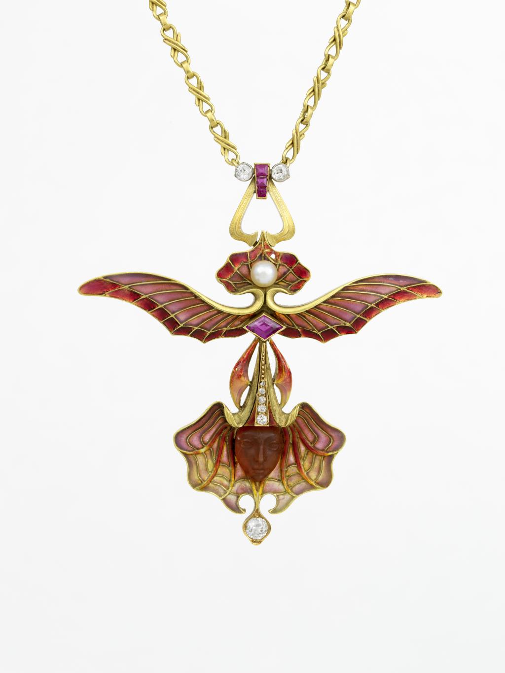Een hanger met de naam 'Gevleugelde orchidee'. De voornaamste kleuren zijn rood en goud, met een paarse diamant en twee witte parels. In het blad van de orchidee zit een klein gezicht. Boven de paarse diamant spreiden twee vleugels zich uit.