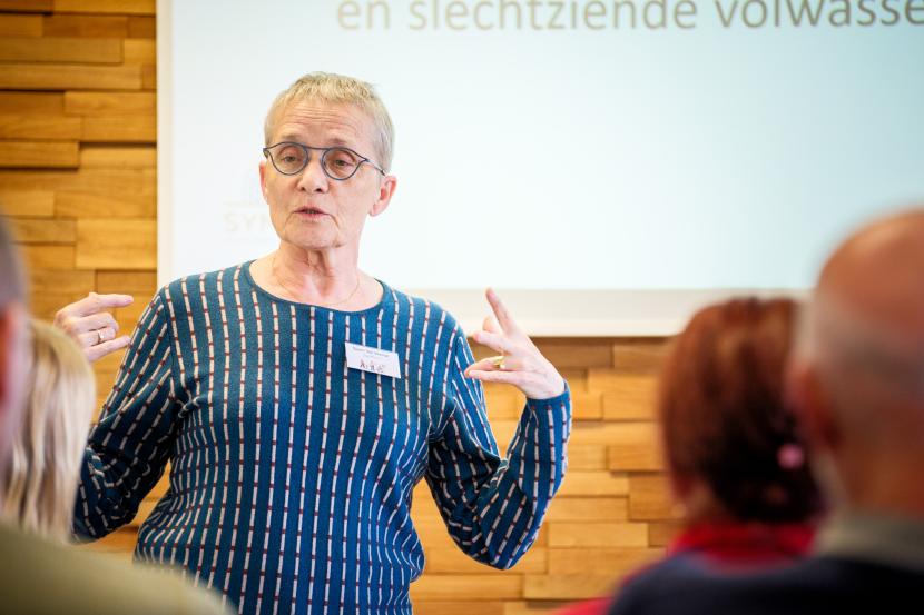 Een foto van voorzitster Geert tijdens haar presentatie op het congres.