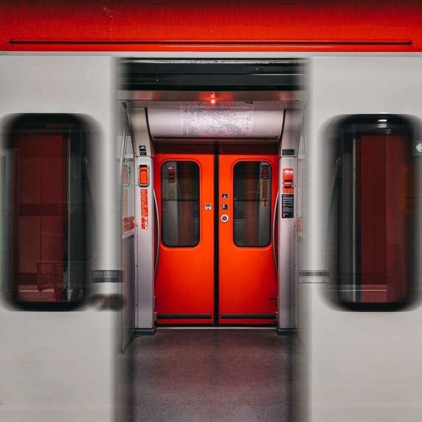 open grijze treindeur met zicht op de gesloten rode achterste treindeurdeur